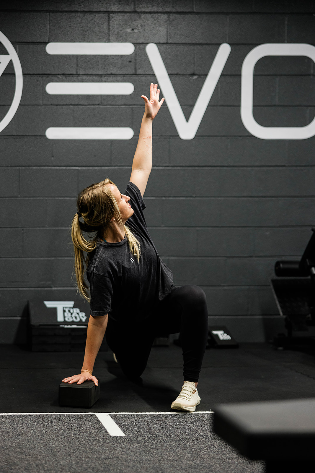 EVO client doing a reach and twist movement assessment in front of the EVO wall